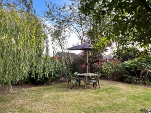 a table and chairs under an umbrella in a yard at The Elegance in Chatteris