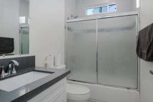 a bathroom with a shower and a toilet and a sink at Comfy 4BR home near Korea Town in Los Angeles +18 photos