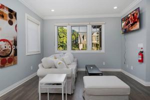 a living room with two white couches and two windows at Comfy 4BR home near Korea Town in Los Angeles
