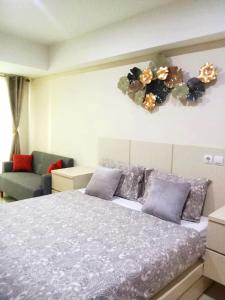 a bedroom with a large bed and a couch at Warhol Residence at Louise Kienne Simpang Lima Semarang in Semarang