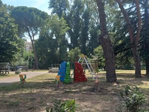 un parco giochi in un parco vicino a un albero di Le Stanze di Bimba a Terni