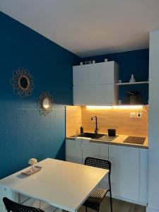 eine Küche mit einem weißen Tisch und einem Waschbecken in der Unterkunft Studio Bord de Mer Boulouris à Saint Raphael in Saint-Raphaël