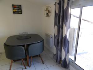 een tafel en 2 stoelen in een kamer met een raam bij Gîtes Le Mas du Vieux Chêne in Salavas