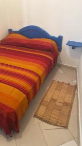 a bed with a colorful blanket next to a table at BLUE RIAD in Safi