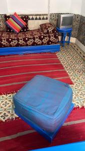 un pouf blu in un soggiorno con divano di BLUE RIAD a Safi