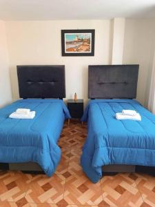 Duas camas num quarto com edredão azul em "A y J Familia Hospedaje" - Free tr4nsfer from the Airport to the Hostel em Lima