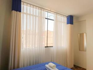 a bedroom with a bed and a window with curtains at A y J Familia Hospedaje in Lima