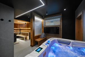 a jacuzzi tub in a room with a tv at TATRA NEST - Apartamenty z Jacuzzi i SPA in Biały Dunajec
