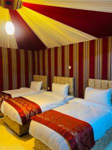 瓦迪拉姆的住宿－Syndebad desert camp，一间卧室设有两张床和条纹墙