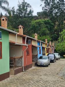 a row of houses with cars parked in a street at Pousada e Restaurante Clima da Serra in Cunha