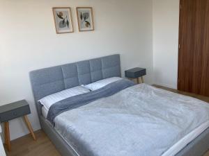 a bedroom with a large bed with two tables at Apartmán 696 Pod Ještědem in Liberec
