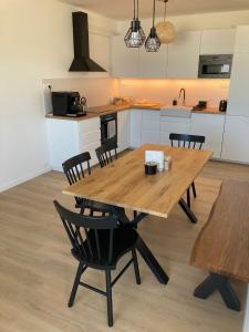 une grande table en bois dans une cuisine avec des chaises dans l'établissement Apartmán 696 Pod Ještědem, à Liberec