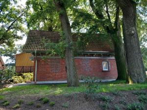 a red brick house with trees in front of it at Ferienhaus Heidenest, mit E-Bike Vermietung in Buchholz in der Nordheide