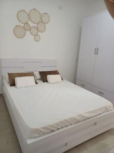 1 dormitorio blanco con 1 cama blanca grande y armarios blancos en יחידת דיור נפרדת עמק המעיינות בית שאן en Bet Sheʼan