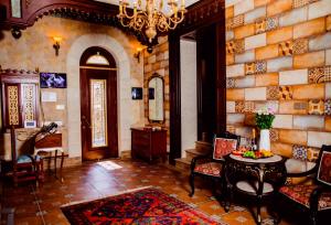 a living room with a chandelier and a stone wall at Royal Historical Boutique Hotel in Baku