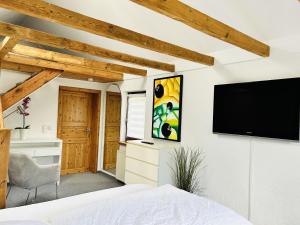 a bedroom with a flat screen tv on a wall at Ferienhaus in Rostock - Brinckmansdorf in Rostock