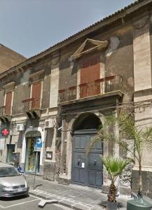a building with a door and a car parked in front of it at Casaurora Centro Storico in Catania