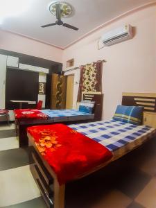 a bedroom with two beds and a tv at m.i. guest house in Bikaner
