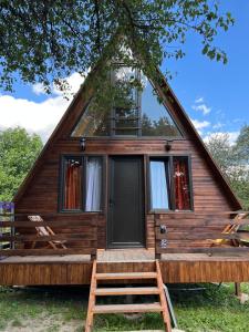 Cabaña con techo de paja, porche y 2 sillas en Cottage Mida, en Mestia