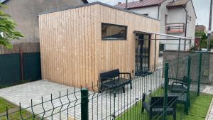 une petite maison avec deux chaises et une clôture dans l'établissement Tiny House, à Pardubice