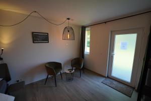 a living room with two chairs and a sliding glass door at B&B Alferweiher in Echternach