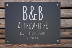 a sign that says bfdauder on a wooden wall at B&B Alferweiher in Echternach +12 photos