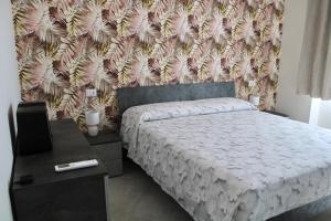 een slaapkamer met een bed en een muur bij DOMIZIANA HOME in Albano Laziale