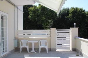 een patio met 2 stoelen, een tafel en een hek bij DOMIZIANA HOME in Albano Laziale