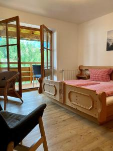um quarto com uma grande cama de madeira e uma cadeira em Gästehaus Alpenhorst em Oberstdorf