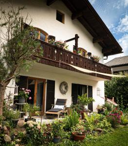 a house with a balcony with a chair and flowers at Engelsherz in Mittenwald
