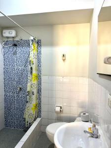 un baño con lavabo y ducha en La Condamine Apart Hotel, en Iquitos