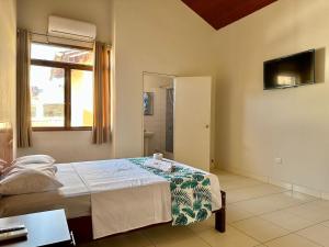 een slaapkamer met een bed en een spiegel bij La Condamine Apart Hotel in Iquitos