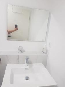 una persona che scatta una foto di un lavandino in bagno di Wohnung Daria a Neu-Anspach