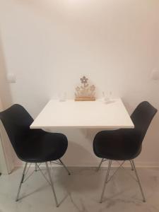 une table blanche avec deux chaises dans une pièce dans l'établissement Wohnung Daria, à Neu-Anspach