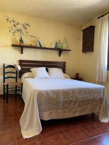 a bedroom with a bed and a chair in it at Molino Los Leones in Ronda
