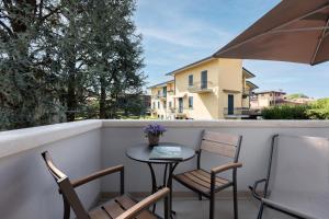 un patio con sedie e un tavolo sul balcone. di Charming Sirmione a Sirmione