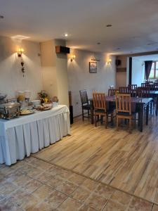 a dining room with a table and tables and chairs at Pensiunea Denim in Şelimbăr