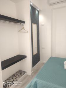 1 dormitorio con cama y espejo en la pared en Summer House en Isola delle Femmine