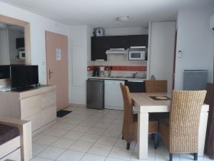 cocina y comedor con mesa y sillas en Appartement 2 Pièces Le Domaine de Manon, en Signes