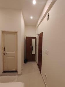 um corredor de um quarto com uma porta e um corredor em MITRA HOTELS em Mysore