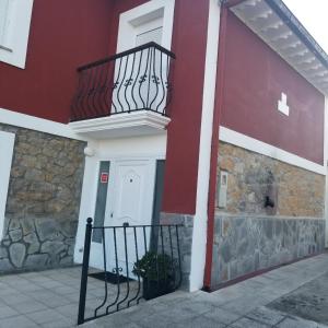 Edificio rojo y blanco con balcón en Casa La Ranera de Santillana en Santillana del Mar