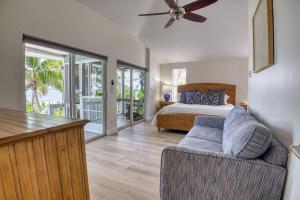 a bedroom with a bed and a couch and a bed and glass doors at BEACHFRONT-Amazing Fishing,Shelling,Sunrise views! in Captiva +43 photos