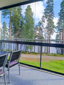 uma varanda com mesa e cadeiras e vista para a água em Laatuhuoneisto Saimaa näkymällä- Luxury apartment by lake Saimaa em Imatra