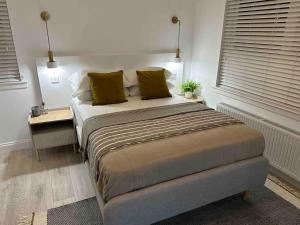Premium executive Apartment in Dunfermline في دنفرملاين: غرفة نوم مع سرير مع كومودينو وسرير sidx sidx