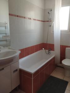 y baño con bañera, lavabo y aseo. en Appartement 2 Pièces Le Domaine de Manon, en Signes