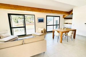 a living room with a couch and a table and chairs at Superbe 3 chambres 150m2 - Parking gratuit, Climatisation, Terrasses - Standing in Bonifacio