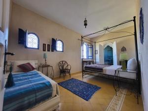 - une chambre avec 2 lits et un miroir dans l'établissement Dar janoub, à Beni Balla