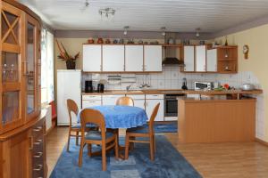 eine Küche mit einem Tisch und Stühlen sowie weißen Schränken in der Unterkunft Ferienunterkünfte Familie Berger in Dessau