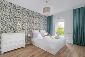 a bedroom with a bed and a green accent wall at Art Deco Point in Poznań