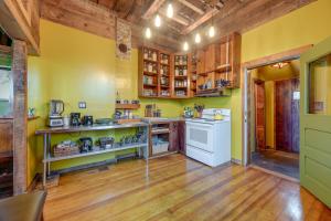 cocina con paredes amarillas y suelo de madera en Klamath Falls Vacation Rental Less Than 1 Mi to Downtown! en Klamath Falls